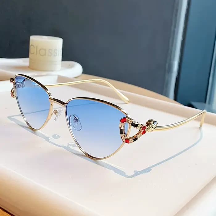 Lunettes de soleil œil de chat dorées tendance 2026 avec ornement tête de serpent